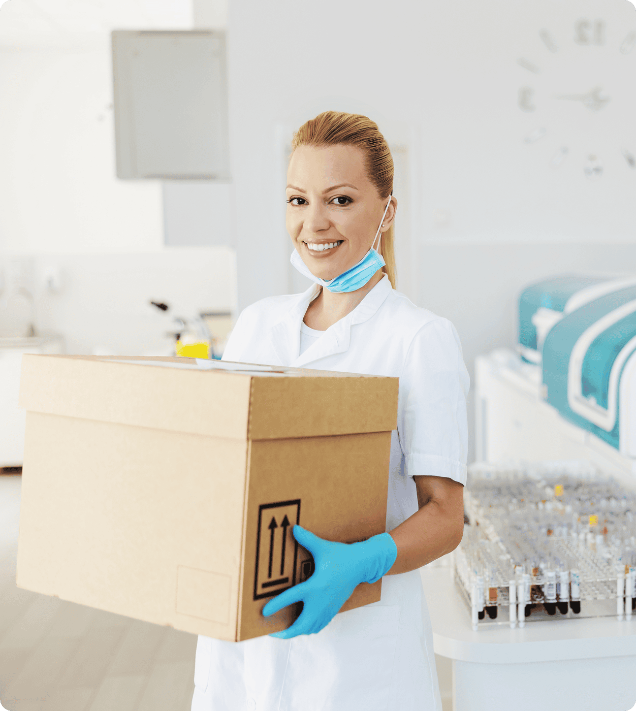 Smiling blond female lab assistant standing and holding box with medicines and vaccine